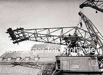 812_1_352 Arbeiter demontieren den Ausleger des 40 Tonnen DEMAG Krans im Altonaer Hafen. Die Arbeitskrfte stehen auf einer provisorischen Holzplattform und lsen mit einem groen Schraubschlssel eine Verbindung. Der Kranausleger wird durch den am Kai liegenden Schwimmkran gesichert.