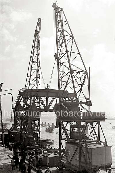 Alte Aufnahmen Altonas - Transport eines 40t Doppel-Lenker Wippkrans; 1938. Altonaer Bilder auf FotoleinwandLeinwand + als Fotoposter.  814_1_359 Zwei Schwimmkrne haben das Untergestell des Altonaer Schwerlastkrans an ihre Haken genommen und bereiten den Transport des Kranteils ber die Elbe vor.