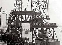 814_1_359 Zwei Schwimmkräne haben das Untergestell des Altonaer Schwerlastkrans an ihre Haken genommen und bereiten den Transport des Kranteils über die Elbe vor.