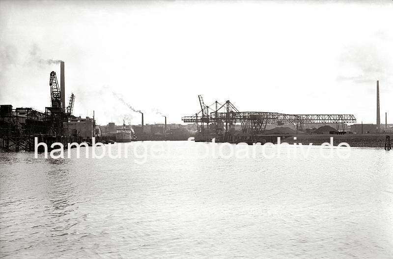 Alte Harburger Bilder - Geschichte des Hafens Harburg;  Kohlenkrne und Industrieanlagen am Harburger Seehafen 2.  820_B_258a Blick von der Sderelbe in den Harburger Seehafen 2; am Kai befinden sich unter den Krnen Kohlehalden. Auf der linken Seite des Hafenbeckens liegen Schuten und ein Seeschiff an der Kaianlage - aus hohen Fabrikschornsteinen steigt Qualm.