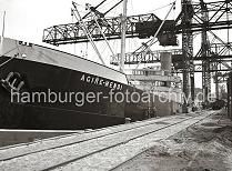 827_B_261 Die Kohlenfracht des Seeschiffs AGIRE-MENDI wird im Seehafens Harburg gelöscht. Auf dem Kai die auf Rädern laufenden Krananlagen, die die Kohle an Land transportieren und gleich in die Güterwaggon verladen.