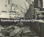 0953998 historische Fotos vom Hamburger Hafen -  Frachter am Auguste Victoria Kai im Kaiser Wilhelm Hafen im Hamburger Hafen. Schuten liegen an der Kaimauer und knnen so mit der Fracht beladen werden. Im Vordergrund bewegt eine Barkasse einen leeren Frachtkahn. Auf dem Kai stehen Krne, die auf Schienen laufen und so die Ladung flexibel transportieren knnen - unter der Krananlage verlaufen die Schienen der Hafenbahn; die beladenen Gterwaggons bringen ihre Ladung in das Hamburger Hinterland.