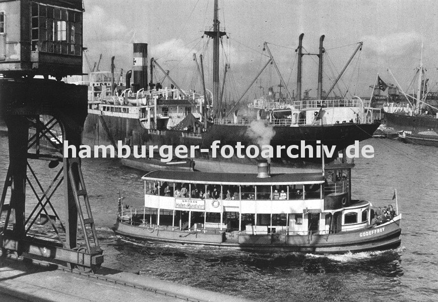 0954001 Ein Schiff der Hamburger Hafenrundfahrt fhrt die Hamburg Touristen durch den Oderhafen - auf dem oberen Deck der GODEFFROY stehen die Hamburg-Besucher und beobachten das Geschehen in Hamburgs Hafen. Im Vordergrund ein fahrbarer Hafenkran am Breslauer Ufer, dahinter ein Frachtschiff mit hochgefahrenem Ladegeschirr - rechts im Hintergrund Schiffe an den Kaianlagen vom Stettiner Ufer. 