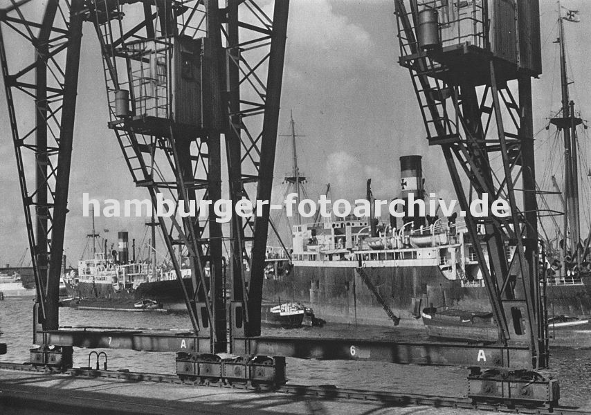0954003 die Krne im Hamburger Hafen laufen auf Schienen -im Vordergrund der Kai Breslauer Ufer im Oderhafen. Schiffe liegen auf Reede im Hafen; Schuten und Binnenschiffe haben an der Bordwand fest gemacht. 