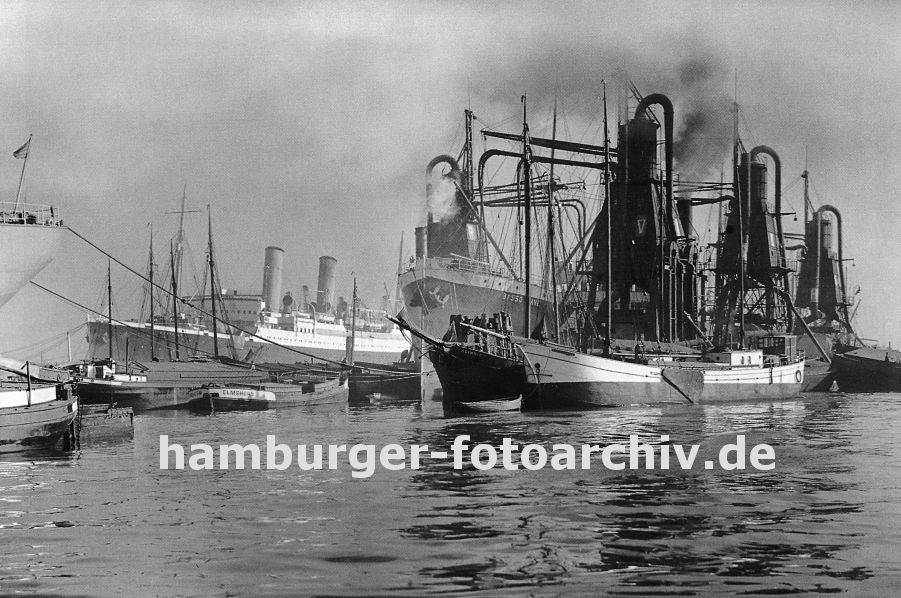 0954011 Im Waltershofer Hafen liegen Schiffe im Hafenbecken; ein Frachter wird mit einem schwimmenden Getreideheber gelscht - das Schttgut wird direkt in lngsseits liegenden Kstenschiffe geladen. 