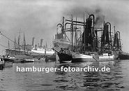 0954011 Im Waltershofer Hafen liegen Schiffe im Hafenbecken; ein Frachter wird mit einem schwimmenden Getreideheber gelöscht - das Schüttgut wird direkt in längsseits liegenden Küstenschiffe geladen. 