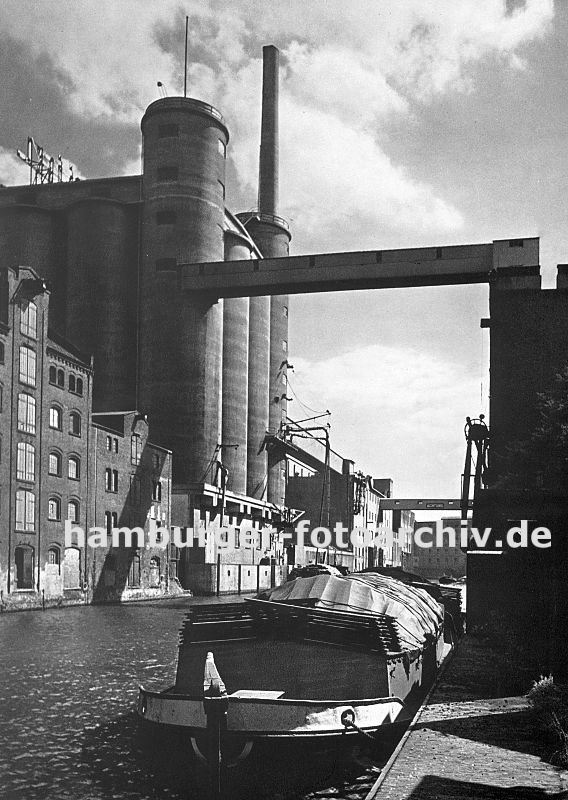 0954019 Blick in den Industriekanal - eine Schute hat am Kai fest gemacht; auf der gegenber liegenden Seite historische Industriearchitektur und ein Getreidesilo. ber den Kanal fhrt eine Frderanlage, die das Getreide in das Silo transportiert. 