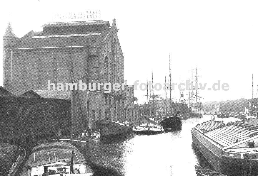 0954020 Fotos aus dem Harburger Hafen - Bild vom Ziegelwiesenkanal -- Blick in den Ziegelwiesenkanal im Harburger Hafen - im Hintergrund ist der Lotsekanal zu erkennen. Frachter und Schuten liegen vor dem Speicher der Harburger lwerke - ber Saugstutzen wird ihre Fracht / Schttgut gelscht / entladen. Andere Schuten und Leichter warten auf ihre Abfertigung; der Laderaum ist mit Brettern oder Planen abgedeckt, damit die Ladung nicht nass wird.