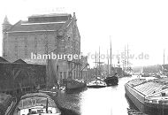 0954020 Blick in den Ziegelwiesenkanal im Harburger Hafen - im Hintergrund ist der Lotsekanal zu erkennen. Frachter und Schuten liegen vor dem Speicher der Harburger lwerke - ber Saugstutzen wird ihre Fracht / Schttgut gelscht / entladen. Andere Schuten und Leichter warten auf ihre Abfertigung; der Laderaum ist mit Brettern oder Planen abgedeckt, damit die Ladung nicht nass wird.