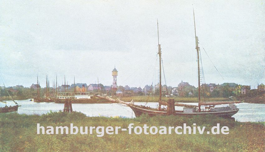 k_0954025 historische Fotografie, Farbe :: Blick ber das Khlfleet nach Finkenwerder; am Ufer liegt ein Segelschiff vor Anker, ein anderes hat den den Dalben fest gemacht. Im Hintergrund die Finkenwaerder Landungsbrcken an der eine Hafenfhre angelegt hat - zwischen den Husern Finkenwerders ragt der Wasserturm von Hamburg Finkenwerder heraus. 