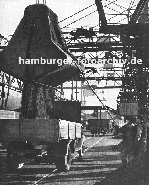 0954040 Kohlekai am Altonaer Hafen; Krne schtten die Kohle in die bereitstehenden Lastwagen -  Hafenarbeiter dirigieren das Schttgut mit einer langen Stange - im Hintergrund ein Gterwaggon auf den Schienen der Hamburger Hafenbahn; darber die Frderanlage fr die angelandete Kohle. 