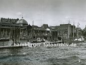 0954057 Hamburgensie als Geschenk zum Geburtstag - Jubilaeum - Hochzeit und Weihnachten --  Fischkutter liegen am Anleger vor der Altonaer Fischauktionshalle - rechts das Khlhaus, in dem der Fang bis zum Weitertransport gekhlt wird. Dahinter verluft die Grenze von Altona und Hamburg; ganz rechts ist die Fischauktionshalle von Hamburg - St.  Pauli zu erkennen. 