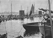 0954059 Bildgeschenk Hamburg-Altona // Fischmarkt in Hamburg Altona; dicht gedrngt liegen die kleinen Khne am Ponton vor der Fischauktionshalle. Die Kunden vergleichen die Ware von den Fischern. Im Hintergrund Hafenanlagen des Hamburger Hafens.