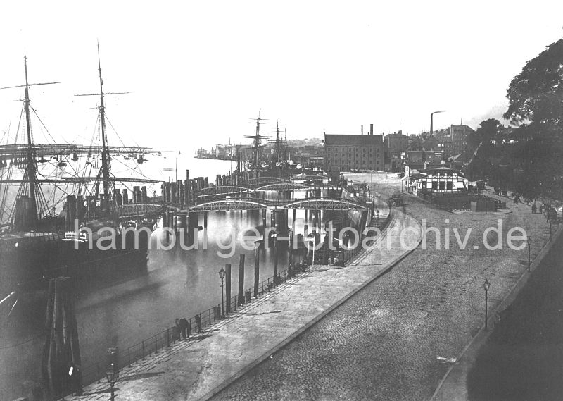 historisches Motiv von den St. Pauli Landungsbrcken - Fhrhaus, Wassertreppen, Duckdalben 0954067_30 DWassertreppen fhren zu den Anlege-Pontons der St. Pauli Landungsbrcken - die eisernen Treppen sind beweglich, so dass sie den Hhenunterschied der Tide (ca. 3,60m) ausgeglichen werden kann. An den Holzpfhlen (Duckdalben) machen die Segler im Strom fest. Rechts das St. Pauli Fhrhaus und im Hintergrund Industriearchitektur von Altona. Sie mchten dieses Motiv z.B. auf Fotoleinwand erwerben? www.hamburg- bilder.biz