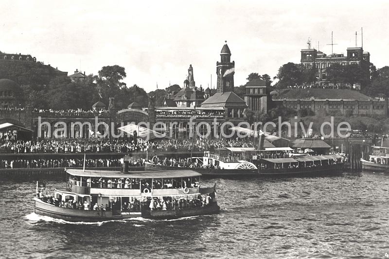 0954081 Dicht gedrngt stehen die Besucher auf den St. Pauli Landungsbrcken - ein vollbesetzter Ausflugsdampfer fhrt auf der Elbe; ein anderer hat am Anleger fest gemacht. Hinter dem Dach des St. Pauli Fhrhauses ist das Bismarck-Denkmal zu erkennne - rechts das Gebude der Hamburger Seewarte auf dem Stintfang, darunter die Hochbahnhaltestelle Landungsbrcken.  0954081 Dicht gedrngt stehen die Besucher auf den St. Pauli Landungsbrcken - ein vollbesetzter Ausflugsdampfer fhrt auf der Elbe; ein anderer hat am Anleger fest gemacht. Hinter dem Dach des St. Pauli Fhrhauses ist das Bismarck-Denkmal zu erkennne - rechts das Gebude der Hamburger Seewarte auf dem Stintfang, darunter die Hochbahnhaltestelle Landungsbrcken.