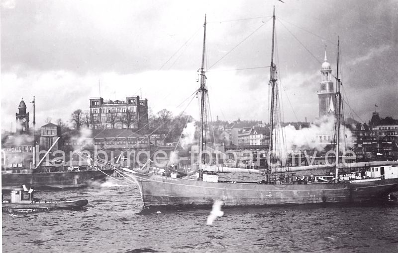 historische Hamburgfotos - Landungsbrcken mit Seewarte und St. Michaeliskirche, Dreimaster.  0954082 Ein Dreimaster wird von einem Schlepper aus dem Hamburger Hafen geschleppt. Am Elbufer links der Uhrturm von den St. Pauli Landungsbrcken, daneben der Eingang von der Hochbahnstation Landungsbrcken sowie das Gebude der Hamburger Seewarte auf dem Stintfang. Rechts der Turm der St. Michaeliskirche - dem Hamburger Wahrzeichen, dass die einlaufenden Schiffe auf der Elbe begrsst. 