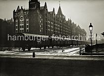 01147754_OF_121 Ein langer Gterzug mit geschlossenen Waggons steht auf den Gleisanlagen des Brooktorkais. Ein Laterne leuchtet in der Nacht - auf der anderen Seite der Gleise der Hafenbahn liegt die neogotische Backstein- Architektur der Speicherblcke V, X und Z