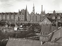 01147757_567a Blick ber den Sandtorhafen zu den neogotischen Backsteinbauten der Hamburger Speicherstadt. Am Sandtorkai liegt ein Frachtschiff, dahinter die Hafenkrne vor dem Lagerschuppen 7. Hinter den Speicherblcken Q und O sind die Kirchtrme der St. Nikolaikirche und der St. Katharinenkirche zu erkennen. 