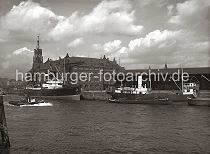 01161_106 Blick vom Strandhft ber die Einfahrt des Grasbrookhafens, ein Motorschiff und Schuten liegen am Dalmannkai vor dem Kaischuppen 13. Links der Kaispeicher A mit dem Uhrenturm - am Kaiserhft hat das Frachtschiff Sutherland festgemacht. Im Hintergrund sind Wohnhuser am  Johannisbollwerk und das Gebude der Seewarte hinter dem Turm der Gustav-Adolf-Kirche zu erkennen.