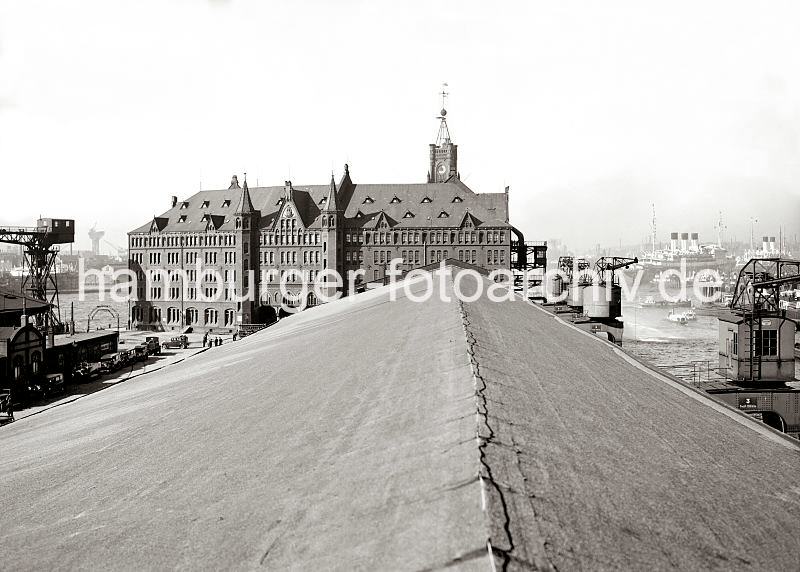 Historische Bilder vom Hamburger Hafen - Backsteinarchitektur des Kaispeicher A, Uhrturm - Dach vom Speicher 12 am Kaiserkai; ca. 1934. 01164_629 Blick vom Dach des Kaispeichers 12 am Sandtorhafens auf das Gebude des Kaispeichers am Kaiserhft - rechts befinden sich die Halbportalkrne am Kaiserkai und im Hintergrund liegen zwei Passagierschiffe an der berseebrcke. Links unten steht eine Reihe von Personenkraftwagen vor der Speisehalle -  daneben ist ein Fahrzeug der Feuerwehr und Lschschlauch zu erkennen.