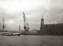 01165_11025T Ein 25 t Schwimmkran fhrt auf der Elbe vor Kaiserhft - lks. der Kaispeicher A / Kaiserspeicher, der 1875 fertig gestellt wurde.  Auf seinem Turm ist eine Zeitballanlage errichtet, die von der Sternwarte am Millerntor ausgelst wird. Der Ball hatte einen Durchmesser von einem Meter und wird exakt Mittags um 12.00 Uhr weit sichtbar fallen gelassen. Im Hintergrund der Turm des Hamburger Michels, die St. Michaeliskirche - das Wahrzeichen Hamburgs.