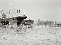 01167_400a Das Motorschiff Bochum liegt im Schwimmdock III der Deutschen Werft vor dem Reiherstieg. Rechts die Einfahrt zum Grasbrookhafen mit dem Kaischuppen 13, dahinter der Giebelturm des Speicherblocks J in der Speicherstadt. In der Bildmitte die Seitenansicht des Kaispeiches A / Kaiserspeichers mit dem Uhrenturm, daneben der Kirchturm der St. Michaeliskirche.