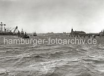 01169_B_215 Blick ber die Elbe Richtung St. Pauli Landungsbrcken. Links die Werftanlagen der Deutschen Werft am Reiherstieg; zwei Schwimmdocks mit eingedockten Schiffen liegen auf der Elbe. In der Bildmitte die Eisenbogen der berseebrcke und re. der Kaispeicher A, der Schuppen 13 am Dalmannkai und der Turm des St. Michaeli Kirche.