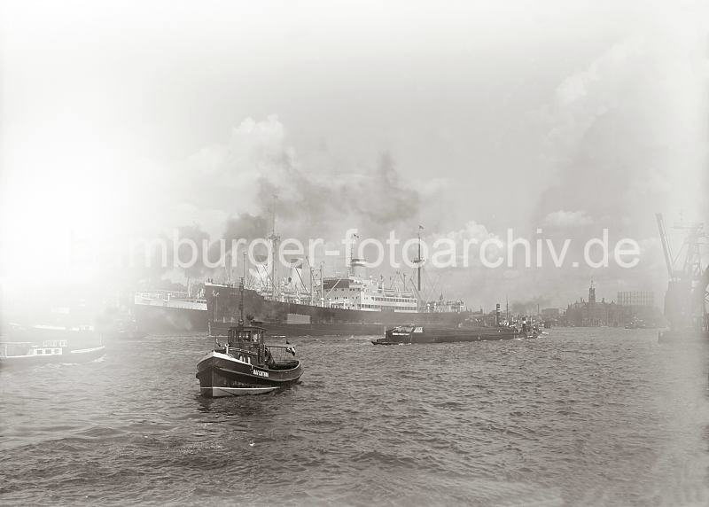 Bilder aus dem historischen Hamburger Hafen - Schiffe unter Dampf - Elbe, berseebrcke + Kaiserkai; ca.1934. 01173_1_617a Das Frachtschiff OAKLAND verlt den Hamburger Hafen - an der berseebrcke liegt das Passagierschiff Monte Pascoal der Hamburg Sd. Dichter Qualm von den Schiffen hat sich ber die Elbe gelegt - kaum sind der Kaiserspeicher und der Gasometer auf dem Grasbrook zu erkennen.