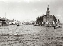 01173_606 Blick von der Elbe in den Sandtorhafen; rechts der Kaispeicher A mit seinem hohen Uhrturm und die Anlegestelle fr die Hafenfhren am Kaiserhft, eine Barkasse mit Fahrgsten an Bord hat gerade abgelegt. Im Hintergrund ist das Kopfgebude am Grasbrookhafen / Strandhft zu erkennen. Am Sandtorkai haben kleinere Frachter fest gemacht whrend am Kaiserkai zumeist Schuten liegen. In der Mitte des Hafenbeckens wird eines der Frachtschiffe von einem Schlepper in die Fahrrinne geschleppt.