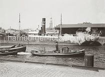 01177_753a Das Frachtschiff CHORZOW liegt vor dem Schuppen 1 am Sandtorkai des Sandtorhafens. Mit zwei Schiffen im Schlepp fhrt der Schlepper PAULINE der Fa. Harms & Sohn Hafenbecken hinein. Im Hintergrund der Turm der St. Michaelis Kirche.