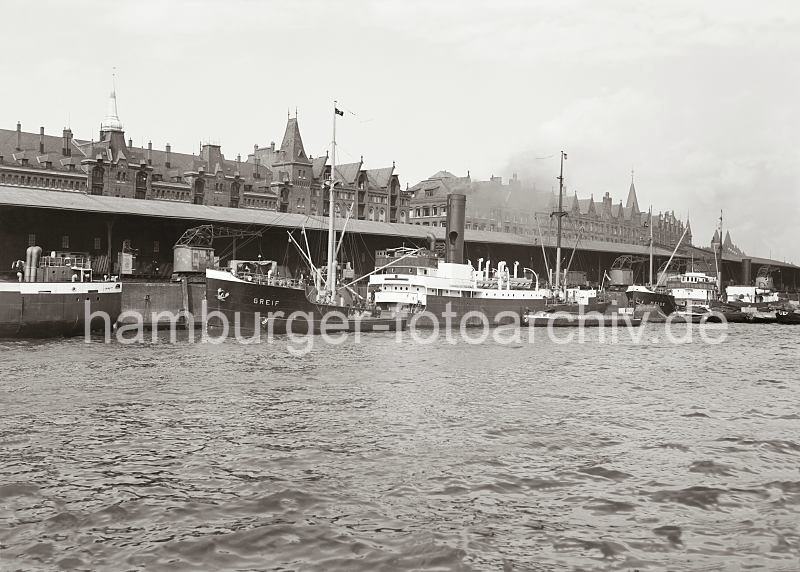 Alte Fotografien aus dem Bildarchiv der HHLA. Frachter am Sandtorkai / Sandtorhafen - Kupfergiebel und Dcher der Speicherstadt - Hamburgensien auf Leinwand oder Posterprints.  02182_618a Drei Kstenmotorschiffe haben am Sandtorkai des Sandtorhafen fest gemacht - in der Mitte der Frachter GREIF und rechts davon die MEISE. Zwischen den Schiffen ist die gelagerte Ware in den zur Wasserseite offenen Kaischuppen 2 zu erkennen. Auf den Schienen laufen die Rollkrne am Hafenkai entlang. Hinter dem Dach des Lagerschuppens sind die Giebel und Winden der Speicherblcke K und L an der Strae Am Sandtorkai zu erkennen.