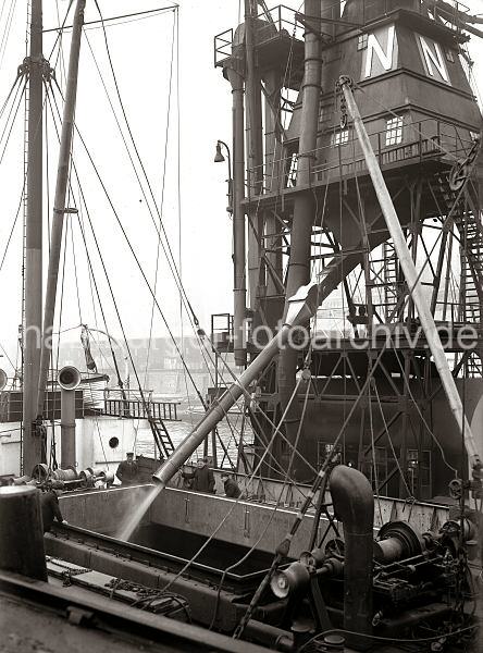 Hamburger Hafenfotos aus dem Bildarchiv der HHLA. Schwimmender Getreideheber am Kaiserkai / Sandtorhafen - Hamburgbilder auf Foto-Leinwand oder Posterprints. 02189_180 Der Getreideheber schttet das aufgesaugte Getreide ber ein Auslaufrohr in den Laderaum des Massengutfrachters im Hamburger Hafen / Kaiserkai.