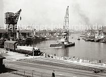 02191_91 Dicht gedrngt liegen Dampfschiffe, Binnenschiffe, Schuten und Elbkhne am Kaiserkai und Sandtorkai des Sandtor- hafens. Ein Schwimmkran fhrt mit eigenem Antrieb Richtung Elbe. Ein Gterzug steht auf den Gleisen des Kaiserkais.