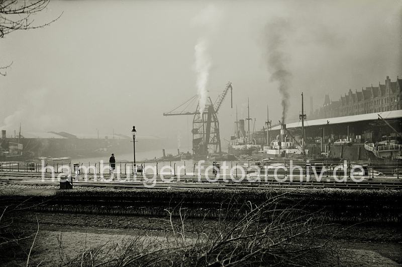 Bilder zur Geschichte des Sandtorhafens. Gleise der Hamburger Hafenbahn am Sandtorhafen - Kohlenheber am  Sandtorkai. Hafenfotos auf Foto-Leinwand und FotoPoster. 02197_OF_109 Der Sandtorhafen im Winter - die Dcher der Lagerschuppen am Sandtorkai und Kaiserkai sind mit Schnee bedeckt. Rauch steigt aus dem Schornstein des Kohlenhebers und eines der Kstenmotorschiffe, die am Kai des Sandtorhafens liegen.
