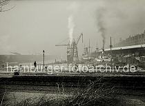 02197_OF_109 Der Sandtorhafen im Winter - die Dcher der Lagerschuppen am Sandtorkai und Kaiserkai sind mit Schnee bedeckt. Rauch steigt aus dem Schornstein des Kohlenhebers und eines der Kstenmotorschiffe, die am Kai des Sandtorhafens liegen.