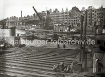 02199_2 Mit Hilfe von Schuten und Barkassen wird eine durch Kriegseinwirkungen ins Hafenwasser gestrzte Lokomotive der Hafenbahn im Sandtorhafen zum Schwimmkran geschleppt. Am Sandtorkai liegen Arbeitsboote und ein anscheinend beschdigter Kohlenheber. Die leeren Giebel der Speichergebude ragen in den Himmel - ein Schornstein des Kesselhauses ist zerstrt.