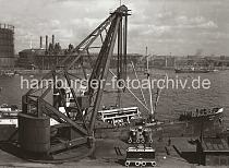 02206_555a Der 1887 errichtete Dampfkran am Kranhft gehrt mit seiner Tragfhigkeit von ca. 150 Tonnen zu den grten der Welt -  er hat eine Hhe von 30m und 10m Ausladung. Der Kran beldt ein russisches Frachtschiff mit Maschinenteilen. Im Hintergrund lks. die Gasanstalt auf dem grossen Grasbrook und rechts davon die Einfahrt zum Magdeburger und Baakenhafen.