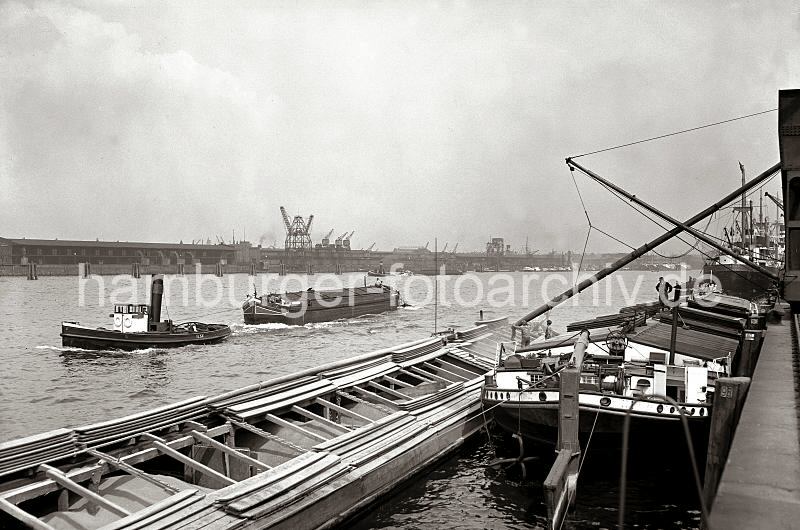 02223_B_238 Binnenschiffe liegen am Holthusenkai in der Norderelbe - ber ein Rohr wird eines der Lastschiffe mit Schttgut befllt; Schlepper ziehen Transportschiffe Richtung Hafen. Am Kirchenpauerkai liegt Kohlenheber und mehrere Schiffe an den Dalben in der Elbe. Historische Hamburgbilder aus dem Hafen; Elblastkhne am Holthusenkai - Norderelbe + Kirchenpauerkai; ca. 1934 - Fotos auf Foto-Leinwand, Posterprint als Geschenk fuer Jubilaeum, Abschied + Geburtstag. 