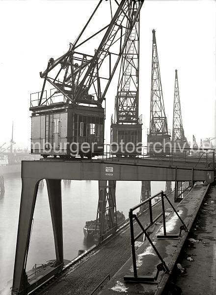 Halbportalkrne am Versmannkai - Baakenhafen; ca. 1935. Alte Hamburgbilder als Geschenk zum Jubilaeum + Geburtstag fr Bro und Wohnung; Fotoleinwand + Posterprints. 02231_191 Blick auf die Halbportalkrne vor den Fruchtschuppen am Versmannkai. Ein Schild an dem Portal des Krans weist auf dessen Tragkraft von 3000 kg hin, das Baujahr ist 1929 und die Hersteller- firma KAMPNAGEL; Hamburg. (Bilder von der Arbeit im Fruchtschuppen / Verladung von Frchten etc. finden Sie hier.