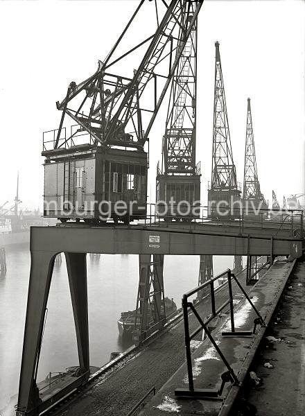 Halbportalkrne am Versmannkai - Baakenhafen; ca. 1935. Alte Hamburgbilder als Geschenk zum Jubilaeum + Geburtstag fr Bro und Wohnung; Fotoleinwand + Posterprints. 02231_191 Blick auf die Halbportalkrne vor den Fruchtschuppen am Versmannkai. Ein Schild an dem Portal des Krans weist auf dessen Tragkraft von 3000 kg hin, das Baujahr ist 1929 und die Hersteller- firma KAMPNAGEL; Hamburg. (Bilder von der Arbeit im Fruchtschuppen / Verladung von Frchten etc. finden Sie hier.