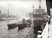 02249_B_334 U-Boote und ein U-Boot Begleitschiff haben am Versmannkai im Hamburger Baakenhafen fest gemacht. Hoher Schnee liegt auf der Kaianlage - ein Kaiarbeiter schaufelt unter dem Portal eines Halbportalkrans die Kaifläche frei.