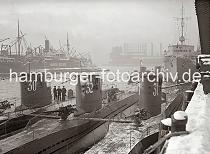 02250_B_334a Drei U-Boote liegen nebeneinander am Versmannkai vor den Fruchtschuppen des Baakenhafens; der Kai ist mit Schnee bedeckt. Im Hintergrund ist das Gasometer beim Magdeburger Hafen zu erkennen.
