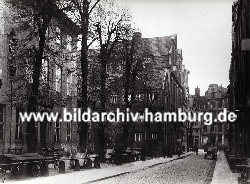 01147706 Hamburg Bilder ::: der alte Wandrahm im Gebiet der der zuknftigen Hamburger Speicherstadt - die Strasse ist mit Kopfstein gepflastert, ein Pferdewagen mit Kisten beladen steht am Strassenrand. Leere Karren / Schottsche Karren sind auf einem Hof abgestellt - eine dekorative Skulptur ist in das Gebude am linken Bildrand eingelassen; die historische Hamburger Architektur mit ihrer Barockfassade den Wohnhusern steht kurz vor dem Abriss. Durch den Zollanschluss Hamburgs 1888 an Preuen entstand der Hamburger Freihafen - ca. 20 000 Menschen, die hier lebten mussten umgesiedelt werden - die Wohn- und Lagerhuser wurden abgerissen und die Speicherstadt errichtet. 