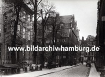 01147706 der alte Wandrahm im Gebiet der der zuknftigen Hamburger Speicherstadt - die Strasse ist mit Kopfstein gepflastert, ein Pferdewagen mit Kisten beladen steht am Strassenrand. Leere Karren / Schottsche Karren sind auf einem Hof abgestellt - eine dekorative Skulptur ist in das Gebude am linken Bildrand eingelassen; die historische Hamburger Architektur mit ihrer Barockfassade den Wohnhusern steht kurz vor dem Abriss. Durch den Zollanschluss Hamburgs 1888 an Preuen entstand der Hamburger Freihafen - ca. 20 000 Menschen, die hier lebten mussten umgesiedelt werden - die Wohn- und Lagerhuser wurden abgerissen und die  Speicherstadt errichtet. 