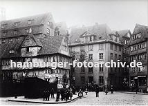 01147709 Strassenkreuzung im Bereich Pickhuben - die historischen Huser stehen dicht gedrngt in dem zuknftigen Areal der Hamburger Speicherstadt. Ein Ladenschild links weist auf eine Barbier Stube hin sowie auf einen Klempner und Mechaniker - rechts gibt es einen Gewrzhandel und dahinter hat ein Geschft mit Haushaltswaren Tpfe an der Hauswand neben dem Schaufenster hngen. Durch den Zollanschluss Hamburgs 1888 an Preuen entstand der Hamburger Freihafen - ca. 20 000 Menschen, die auf den Elbinseln Kehrwieder, Brook und  Wandrahm lebten wurden zwangsumgesiedelt, die Wohn- und Lagerhuser wurden fr den Bau der Speicherstadt abgerissen.