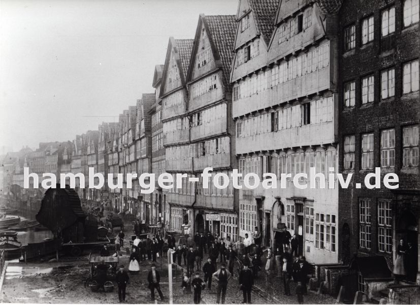 01147711 Bilder Hamburgs Vergangenheit :::  die historische Bebauung am Kehrwieder, Seite zum Binnenhafen; Boote liegen an der Kaimauer - Winden mit rundem Schutzdach stehen in regelmssigen Abstnden am Hafenrand. Schilder an den Husern weisen auf eine Destillation und Weinhandlung und eine Tabakfabrik hin. Durch den Zollanschluss Hamburgs 1888 an Preuen entstand der Hamburger Freihafen - ca. 20 000 Menschen, die auf den Elbinseln Kehrwieder, Brook und  Wandrahm lebten wurden zwangsumgesiedelt und die Wohn- und Lagerhuser fr den Neubau der Speicherstadt abgerissen.