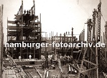 01147715 die Eisentrger des Speicherblock H werden hoch gezogen - Bauarbeiter balancieren auf dem Gerst; einfach zusammen genagelte Holzleitern werden zum Besteigen der Hamburger Grossbaustelle benutzt. Auf provisorisch verlegten Gleisen kann Baumaterial per Handwagen ber das Gelnde der entstehenden Speicherstadt transportiert werden. 