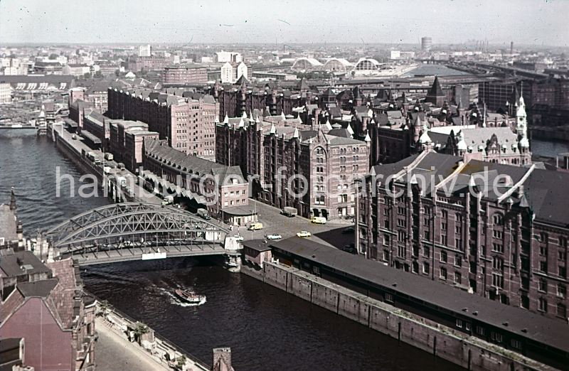 011477210 Blick ber den Zollkanal zur Speicherstadt mit seinen kupfergedeckten Giebeltrmen. An der Kornhausbrcke ist eine Zollstation, da hier das Gelnde des Hamburger Freihafens betreten wurde. Im Hintergrund die geschwungenen Dcher des neuen Blumen- und Gemsemarkt und am Horizont der Gaskessel der Gaswerke in Hamburg Rothenburgsort. Sie mchten das Motiv kaufen? www.hamburg- bilder.biz