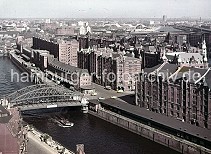 011477210 Blick ber den Zollkanal zur Speicherstadt mit seinen kupfergedeckten Giebeltrmen. An der Kornhausbrcke ist eine Zollstation, da hier das Gelnde des Hamburger Freihafens betreten wurde. Im Hintergrund die geschwungenen Dcher des neuen Blumen- und Gemsemarkt und am Horizont der Gaskessel der Gaswerke in Hamburg Rothenburgsort. Sie mchten das Motiv kaufen? www.hamburg- bilder.biz