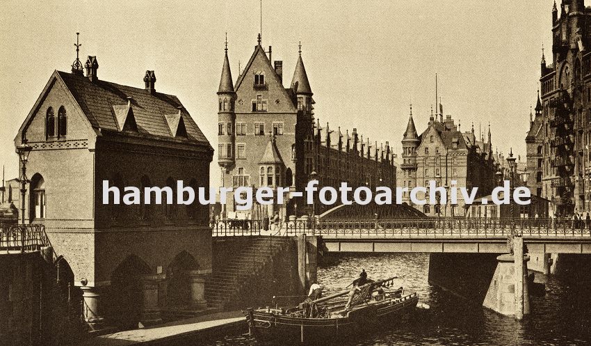 01147727 Hamburgs Geschichte in Fotos -  ein Schiff hat gerade die St. Annenbrcke in der Hamburger Speicherstadt passiert - um die niedrige Brckendurchfahrt zu ermglichen ist der Mast des Schiffes umgelegt. Die Architektur der Speichergebude zeichnet sich Giebel, Erker und Trme aus. Links ein Ponton vor dem (jetzigen)Fleetschlsschen, an dem Boote anlegen knnen, eine Treppe fhrt auf die Strasse hinauf. 